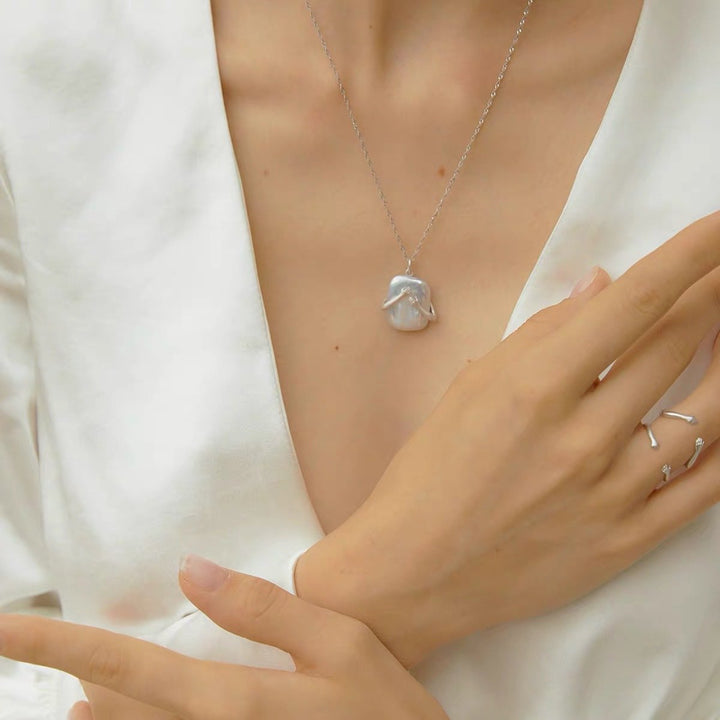 Luxury ring embracing natural baroque pearl necklace