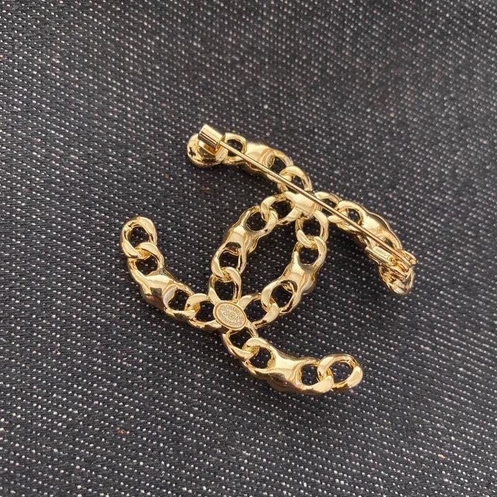 Gold-colored rhinestone brooch